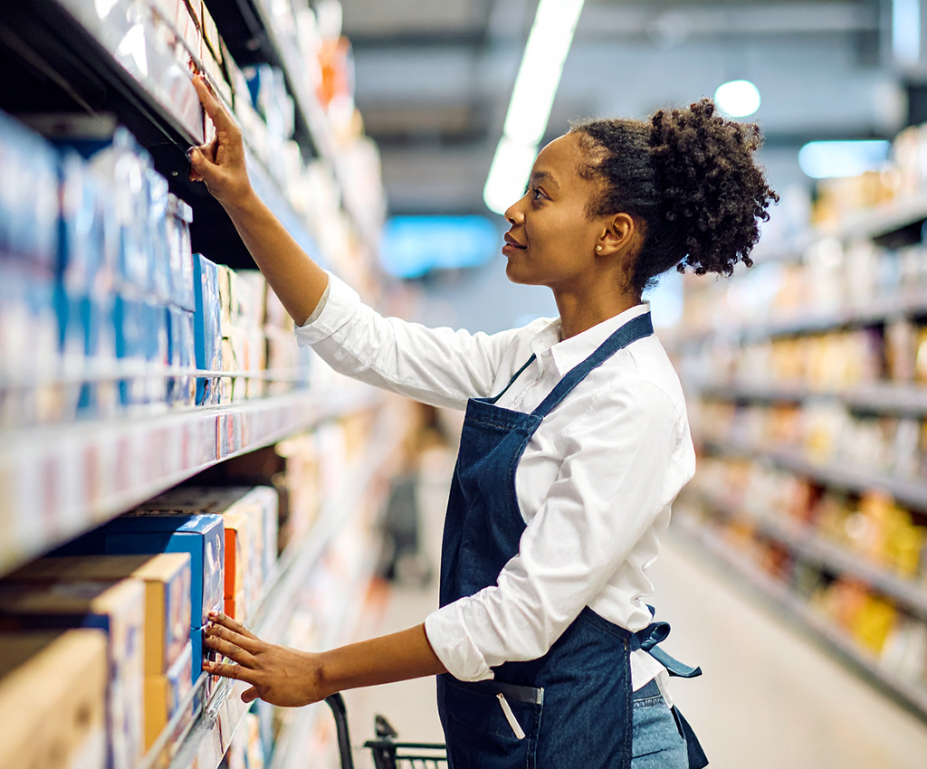 grocery store attendant stocking shelves